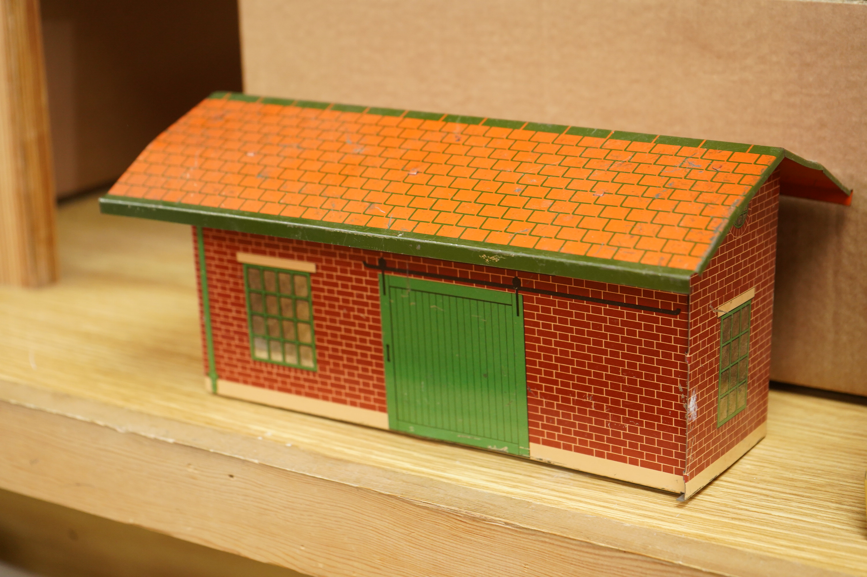 A collection of 0 gauge Hornby tinplate clockwork railway, including four BR locomotives, 17 freight wagons and four wheel coaches, together with a station building, signal cabin, and Goods depot (missing base), plus a f